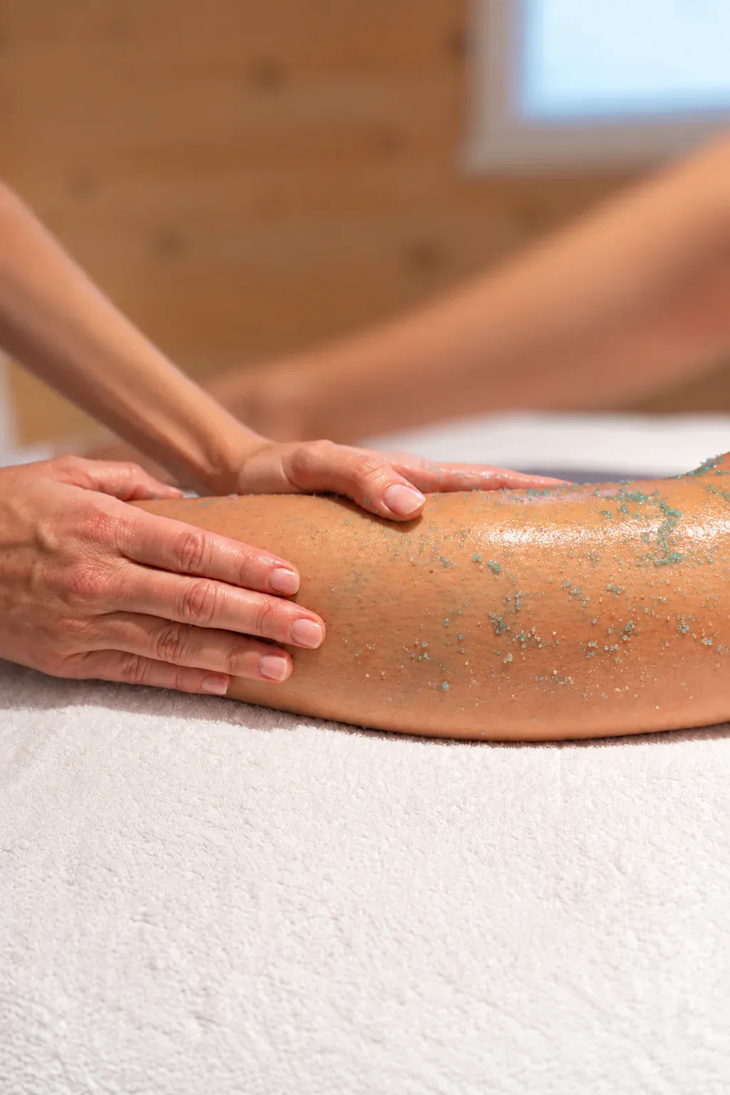 Dettaglio dello scrub sulle gambe durante un trattamento presso La Bellart